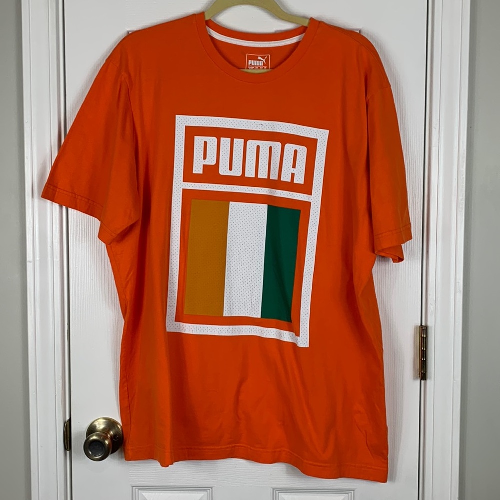 Puma orange short sleeved tee shirt size XL. White lettering. Flag on front.